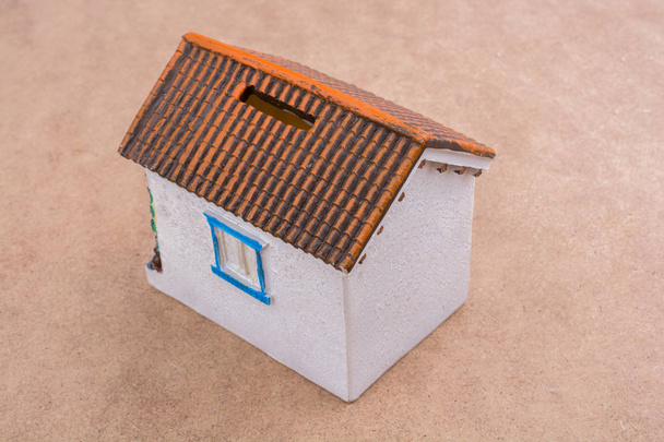 Маленький модельний будинок на коричневому фоні
 - Фото, зображення