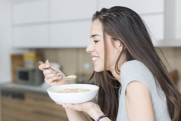 Ευτυχισμένη γυναίκα τρώει υγιεινό πρωινό - Φωτογραφία, εικόνα