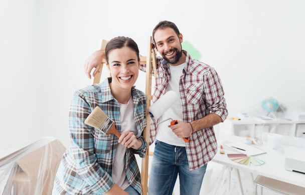 young smiling couple leaning on ladder - Photo, image