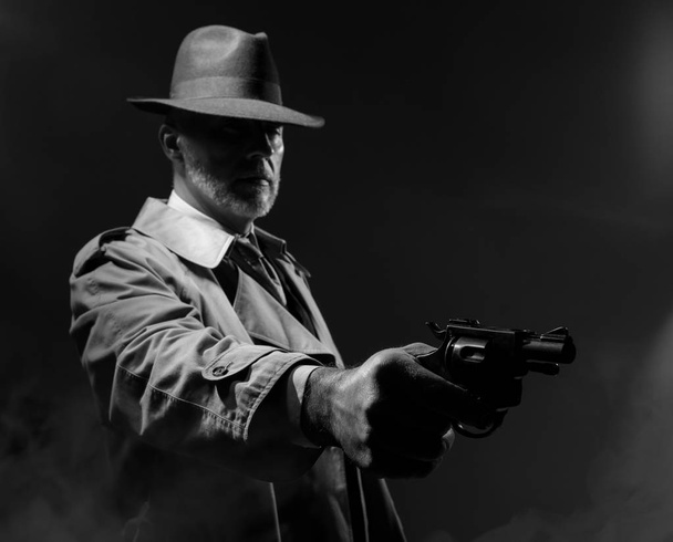 Spy agent pointing gun in dark  - Foto, afbeelding
