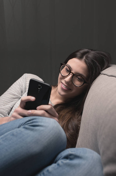 Smiling girl social networking with smartphone - Foto, Imagen