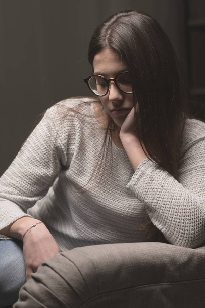depressed woman sitting on couch at home - Foto, Bild