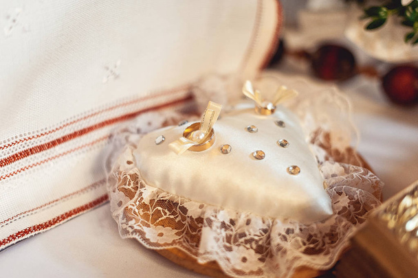 klassischer goldener Ehering auf kleinen herzförmigen Kissen - Foto, Bild