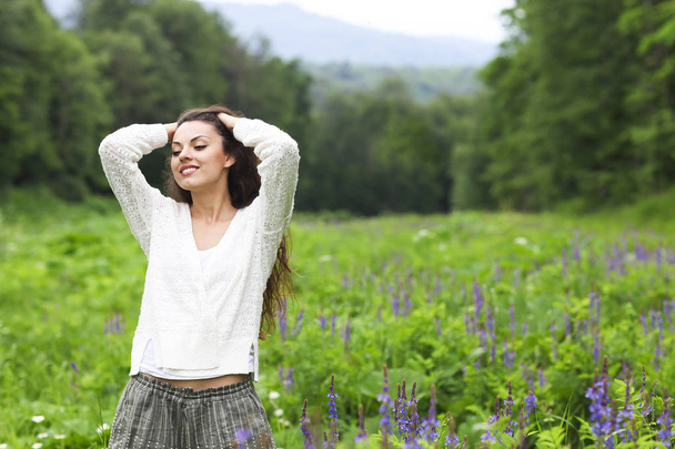 Happy pretty brunette woman in flower field - Foto, immagini