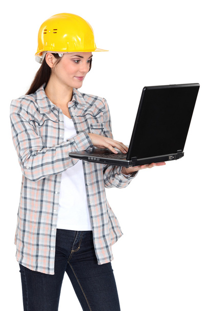 Female builder stood with laptop - 写真・画像