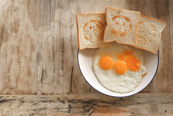 Ψωμί ολικής αλέσεως τοστ με χαμογελαστά σφραγίδα και τηγανητά αυγά  - Φωτογραφία, εικόνα