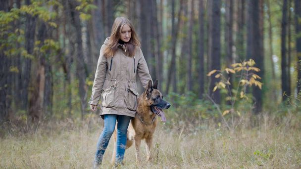 Cute girl playing with her pet - german shepherd in autumn park - Photo, image