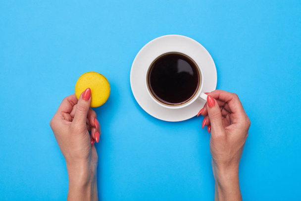 Top view of woman hand holding a cup of coffee over flatlay - Photo, Image