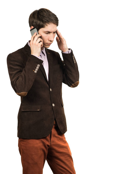 Portrait of a young pensive businessman talking on cell phone - 写真・画像