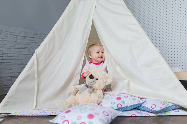 Child playing with a teepee tent - Foto, imagen