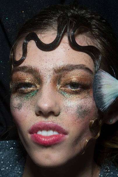 Pretty fashion girl putting holiday glitter makeup - Foto, Imagem