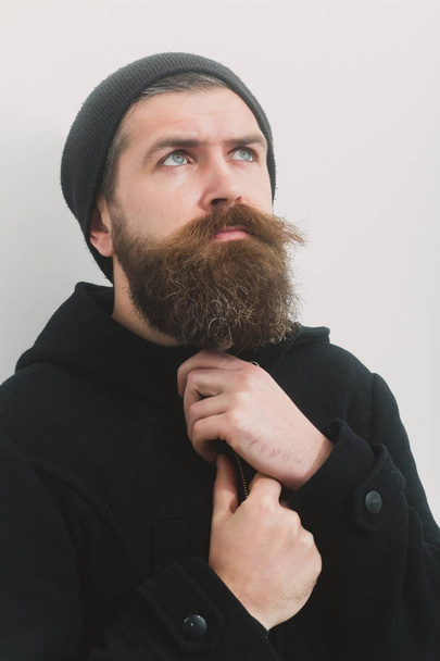 bearded serious brutal caucasian man in black jacket and hat - Zdjęcie, obraz