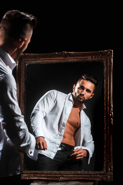 muscular macho man with sexy athlete body near vintage mirror - Фото, изображение
