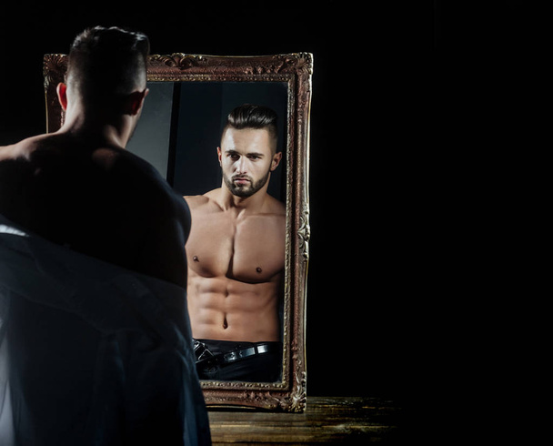 muscular macho man with sexy athlete body near vintage mirror - Zdjęcie, obraz