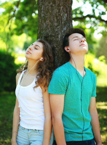 Young couple in headphones enjoying listens to music in the city - Foto, Imagen