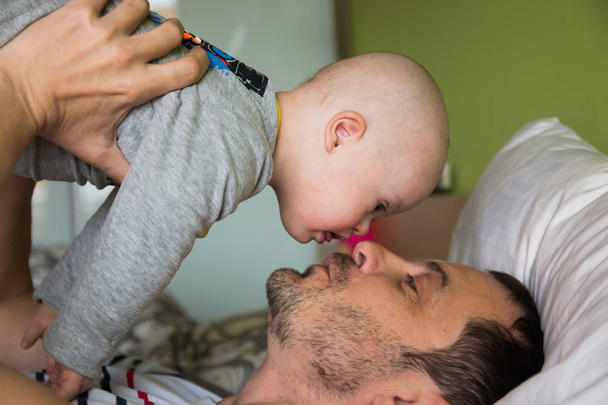 Cute baby boy with Down syndrome playing with dad - Photo, Image