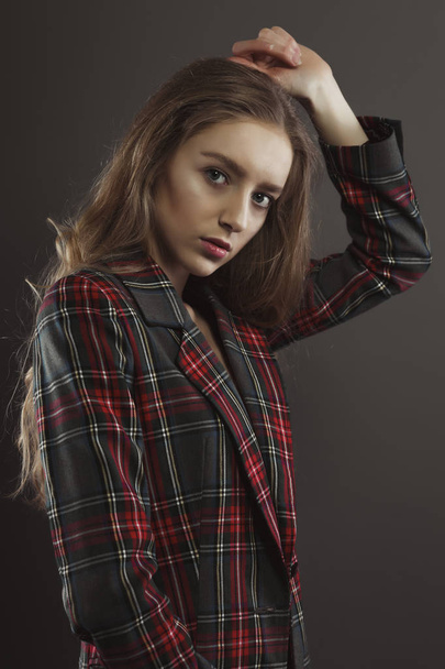 Mulher jovem na moda posando para testes de modelo na jaqueta de tartan
 - Foto, Imagem