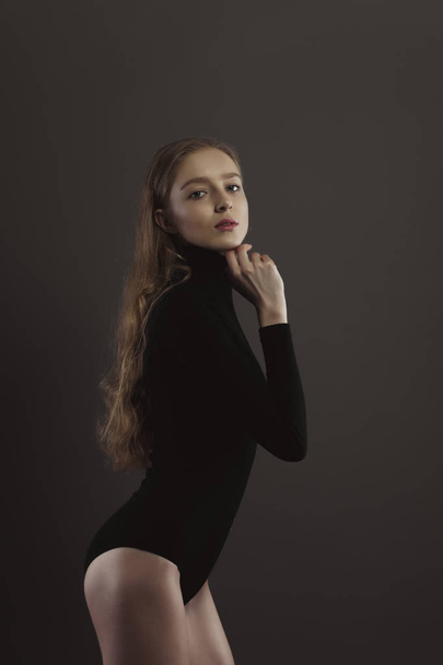 Model test with beautiful woman in black body over a grey studio - Fotó, kép