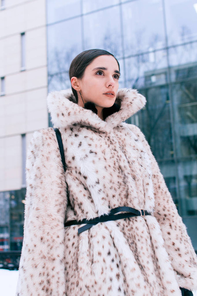Beautiful business woman in a fur coat on a background of office on the street - Foto, immagini