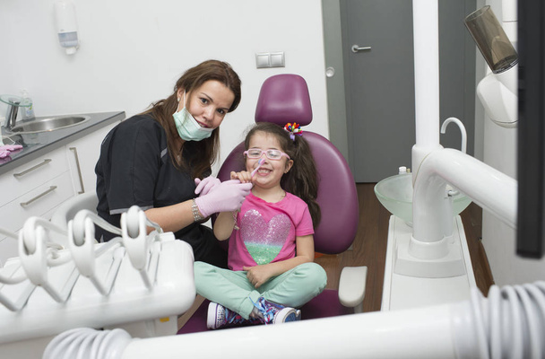 Стоматологи с пациентом во время стоматологического вмешательства к мальчику
 - Фото, изображение