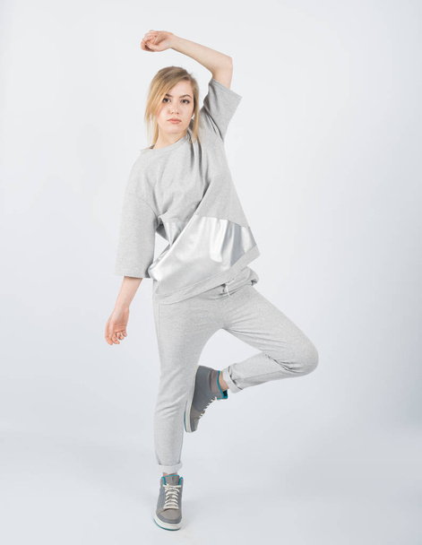 Young beautiful girl wearing grey clothes and sneakers - Photo, Image
