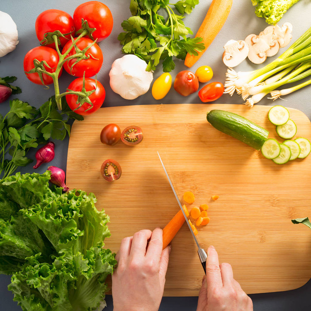 Vista dall'alto della donna che cucina cibo sano: taglio di verdure ingerite
 - Foto, immagini