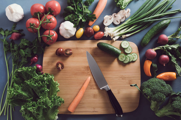 Top view of woman cooking healthy food: cutting vegetable ingred - Fotó, kép