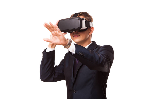 Young handsome businessman in black suit wearing virtual reality goggles., isolated on white background - Zdjęcie, obraz
