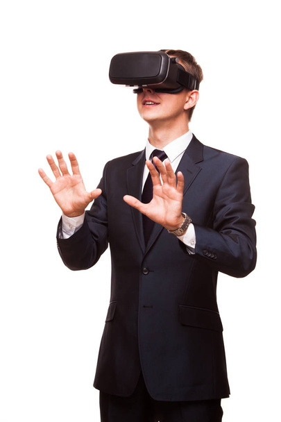 Young handsome businessman in black suit wearing virtual reality goggles., isolated on white background - Foto, immagini
