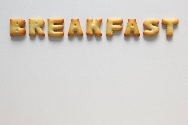 An inscription from the cookies on the white background. Text - breakfast. - Fotoğraf, Görsel