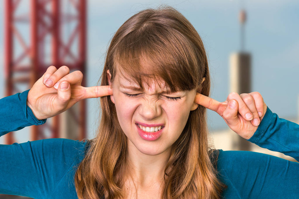 Nő kiterjedő a fülét, hogy megvédje a hangos zaj - Fotó, kép