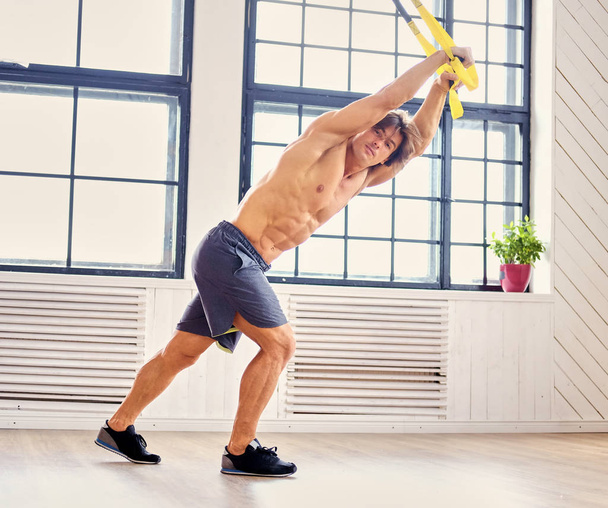 Man exercising with fitness trx straps - Fotó, kép