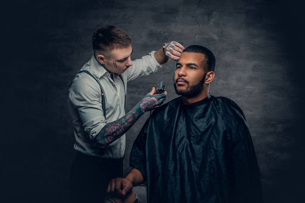 Peluquero tatuado cortando la barba
 - Foto, imagen