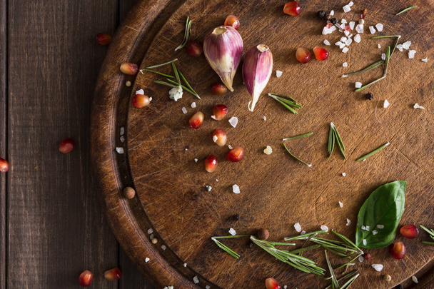 Empty cutting board background with scattered spices, herbs and garlic - Photo, Image