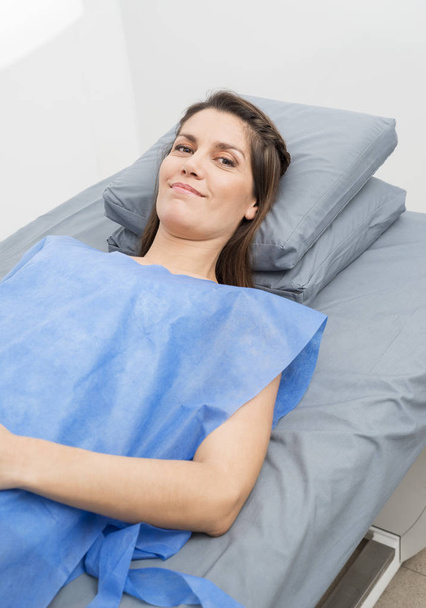 Female Patient In Protective Clothing Lying On Hospital Bed - Valokuva, kuva
