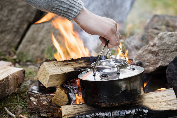 Hand Holding Cooking Pot Over Bonfire - Foto, immagini