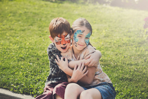 Happy children, boy and girl with face paint in park - Photo, Image