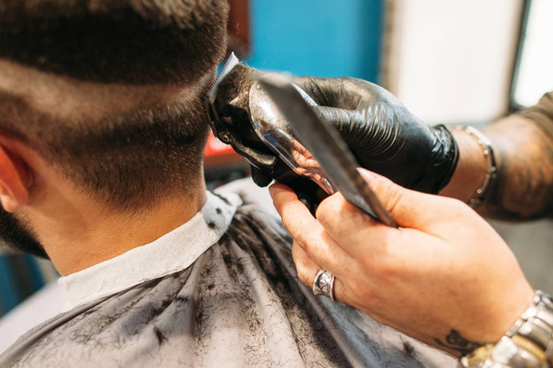 Man making curly haircut at barber shop closeup - Foto, afbeelding