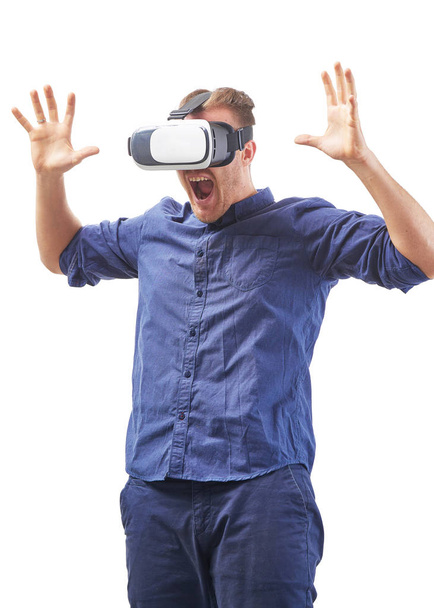 Huutava nuori mies käyttää VR kuulokkeet nauttia interaktiivinen peli pelko tunteita ja kokea virtuaalitodellisuus eristetty valkoisella taustalla studio ammuttu
 - Valokuva, kuva
