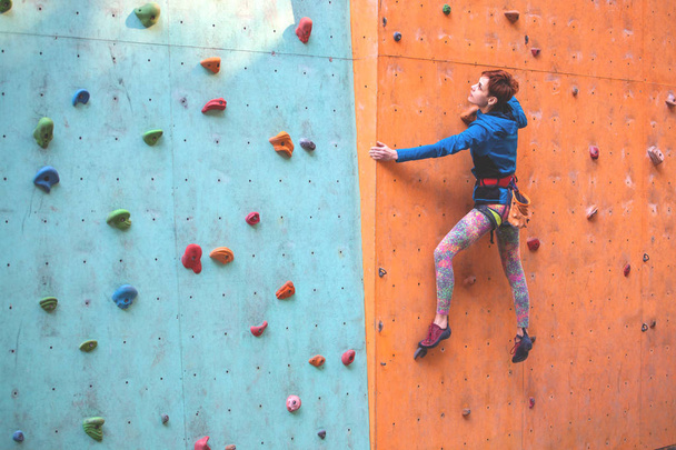 The girl climbs on the climbing wall. - Zdjęcie, obraz