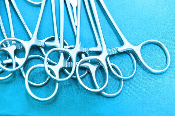 Детальный снимок стерилизованных хирургических инструментов с помощью руки, хватающей инструмент  - Фото, изображение