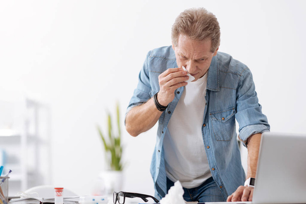 Sick man wiping his nose - Фото, изображение