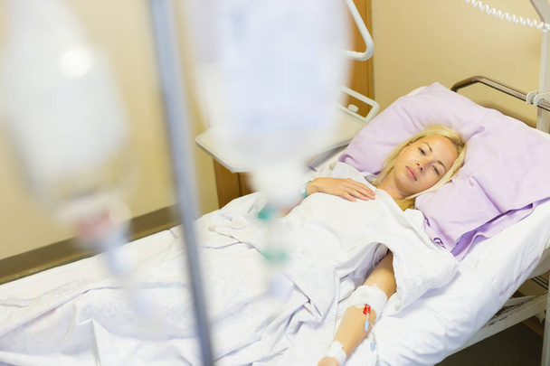 Bedridden female patient recovering after surgery in hospital care. - Foto, Imagem