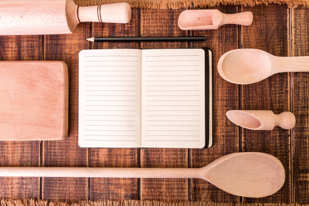 Книга для рецепта навколо посуду на дерев'яному фоні
 - Фото, зображення