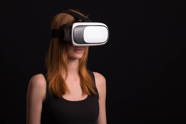 Студийный портрет молодой девушки, играющей с виртуальной реальностью
 - Фото, изображение