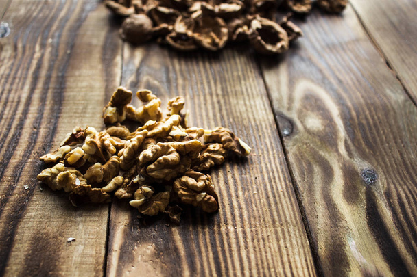 peeled walnuts and shell on wooden background - Zdjęcie, obraz