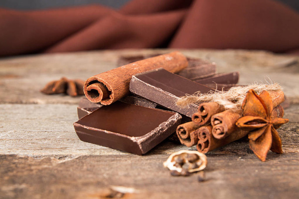 Pila de trozos de chocolate agrietados con canela, estrella de anís
 - Foto, imagen