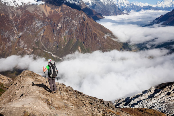 Trekker on the way to the valley covered with cloud on Manaslu c - Foto, Imagen