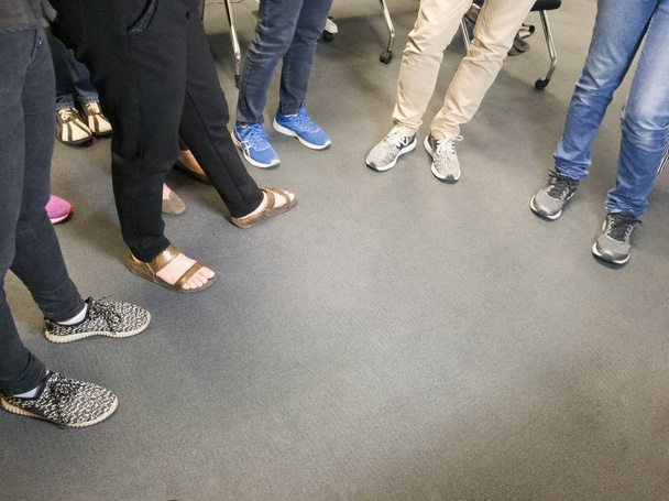 Pessoas em pé em um chão ouvindo para apresentação
 - Foto, Imagem