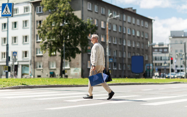 Seniorin mit Einkaufstasche läuft auf Zebrastreifen - Foto, Bild